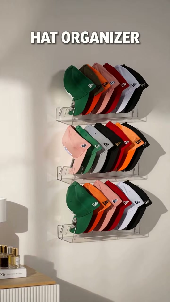 A freestanding acrylic stand that holds a row of caps